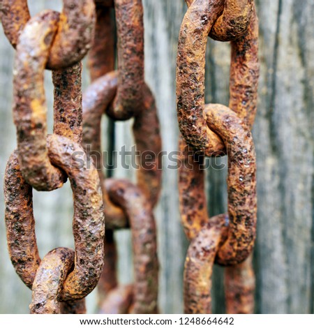 Old rusty metal chains on the wooden background                              
