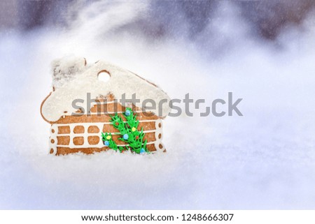 Gingerbread house on a snow outdoor background, Christmas card , snow and smoke effect, inscription of Merry Christmas and happy New Year