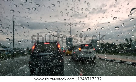 Defocused traffic through wet glass. Bokeh lights and water droplets on the glass.