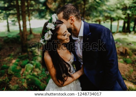 Beautiful wedding couple posing outdoor in forest
