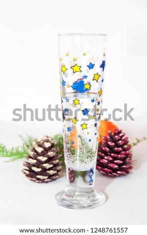  festive decorative glass with a drink and colorful bumps and tangerine
