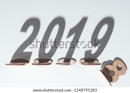 top view of wooden numbers with shadow on white background symbolizing change from 2018 to 2019