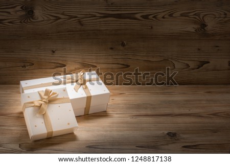 Two Christmas presents nicely wrapped up before a wood background