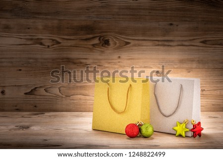 Two shopping bags with christmas decoration in front of a wood background