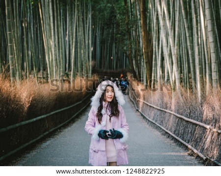 Beautiful asian girl is traveling into Bamboo forest in Kyoto.