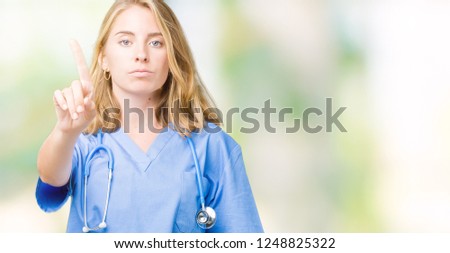 Beautiful young doctor woman wearing medical uniform over isolated background Pointing with finger up and angry expression