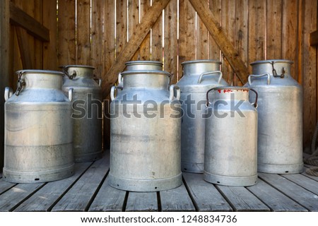 Old aluminium milk cans at dairy farm. Royalty-Free Stock Photo #1248834736