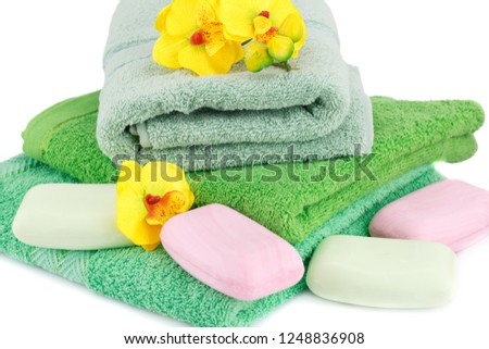 Folded towels, soaps and flowers closeup picture.