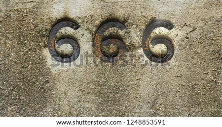 Engraved number 666 on stone background. iron digits, numbers - three six. 