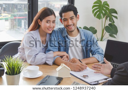 new house / home moving and relocation concept. Happy asian couple signing contract to buy apartment.
