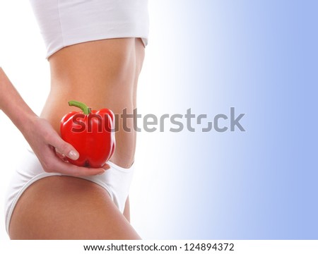 Dieting concept, Beautiful belly and a fruit isolated on blue