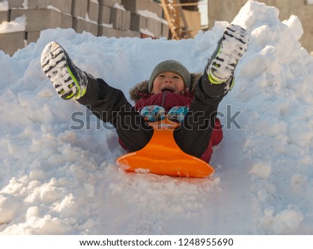 Cute boy sledding in the snow