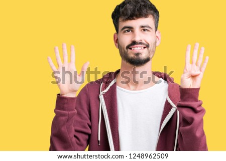 Young handsome man over isolated background showing and pointing up with fingers number nine while smiling confident and happy.