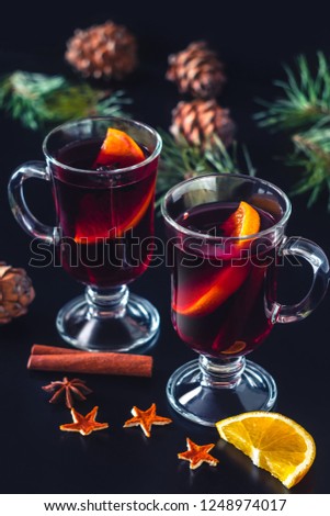 Festive mulled wine on the dark background.Holiday decorations, cones, pine twigs