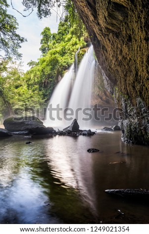 Waterfall on mountain cliff in the tropical rain forest. Beautiful nature waterfall in Khao Yai national park, Nakhonratchasima ,Thailand ,Haew Suwat waterfall. Waterfall view from inside the cave.