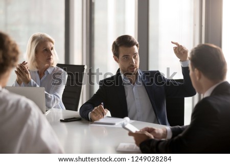 Serious businessmen businesswomen gathered in boardroom discuss new ideas for company growth, discover new ways exploring additional business opportunities solve problems related with small business Royalty-Free Stock Photo #1249028284