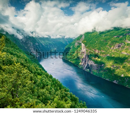 Breathtaking summer scene of Sunnylvsfjorden fjord, Geiranger village location, western Norway. Aerial morning view of famous Seven Sisters waterfalls. Yellow filter toned.