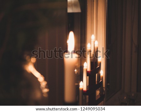 Christmas vintage candle and lights in blurred background. Dark picture.