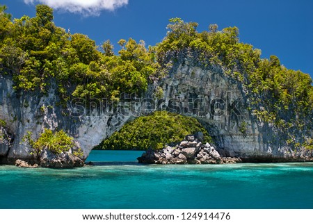 An ancient reef, uplifted millions of years ago, now serves as a limestone island set in the midst of Palau's scenic Rock Islands. Royalty-Free Stock Photo #124914476