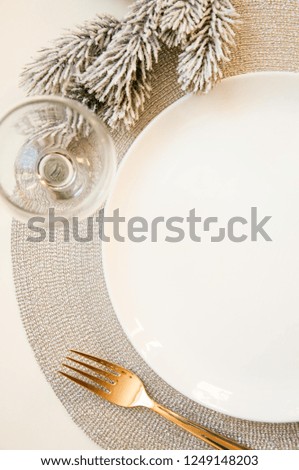 Preparing the table for the celebration of the new year. Lay the table. White plate on a white background. Menu for the new year. Decor winter dishes.