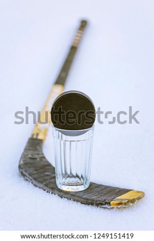 Hockey puck on glass and stick