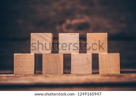 Seven Wooden Cubes on Wood Background with Copyspace