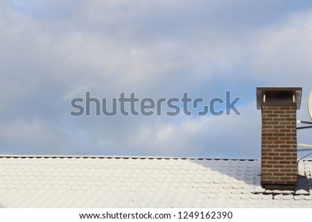 Roof covered with snow and blue sky. White. Snow picture. 