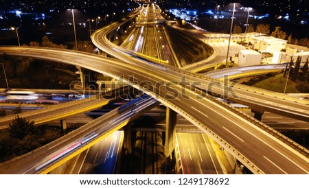 Aerial drone slow shutter night shot of urban elevated toll road junction and interchange overpass in rush hour