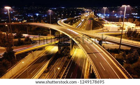 Aerial drone slow shutter night shot of urban elevated toll road junction and interchange overpass in rush hour