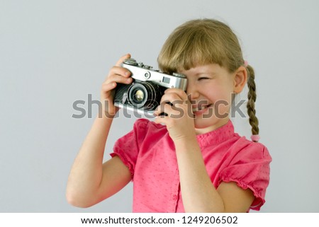 kid, child takes pictures with an old camera