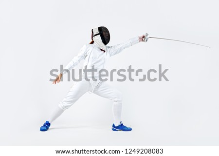 Young fencer athlete wearing mask and white fencing costume. holding the sword. Isolated on white background Royalty-Free Stock Photo #1249208083