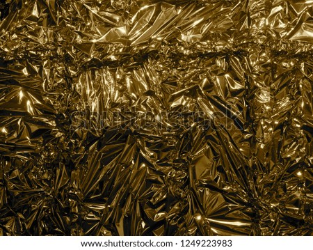 Golden metal foil, wrinkled and shiny.
Close-up, abstract image background