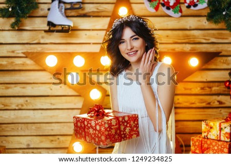 portrait of a beautiful young woman who holds a gift for new year and Christmas.
