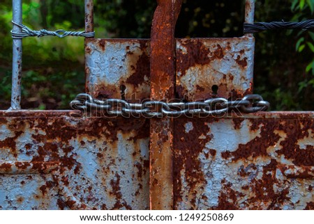 
photo taken on 05-28-16 in Tarragona (Spain). closed door with chains of an uninhabited farm on the outskirts of the city