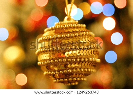 Christmas decoration. Christmas tree, with a beautiful golden xmas ball on the foreground. Background with lights and bokeh effect. Christmas 2018