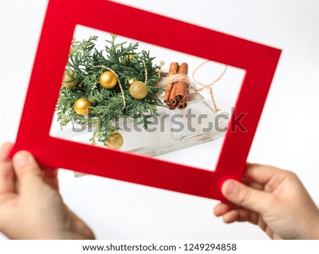 New Year's card with Decorative white sledge with a New Year's fir-tree the decorated Christmas gold spheres and a bundle of firewood. Children's handles hold a red frame for a photo