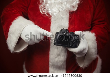 Santa Claus using holding in hands DSLR camera. Christmas and New Year celebration background