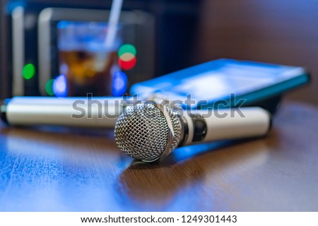 Microphone and remote control in karaoke box Royalty-Free Stock Photo #1249301443