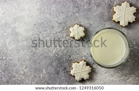 Christmas homemade gingerbread cookies and a glass of milk on the light grey background. Top view