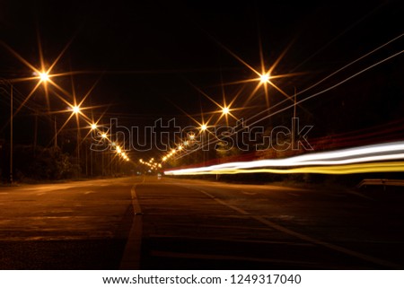Low-light scenery, lanterns and twilight headlights on rural paved streets with electric poles and trees.