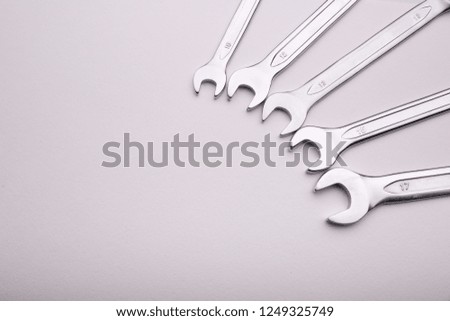 wrenches lie on a white background in a semicircle at the side