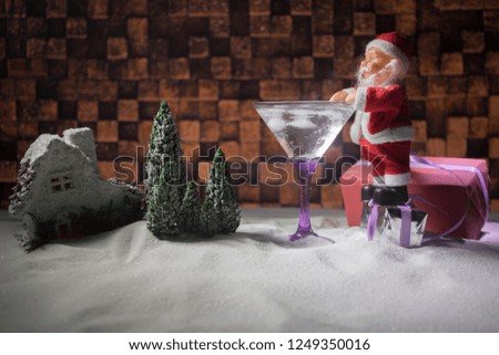 Winter Cocktail - Alcoholic drink and snow scene with a Christmas theme or Ideas and recipes for Christmas drink. Glass of martini on snow with Christmas decoration, copy space