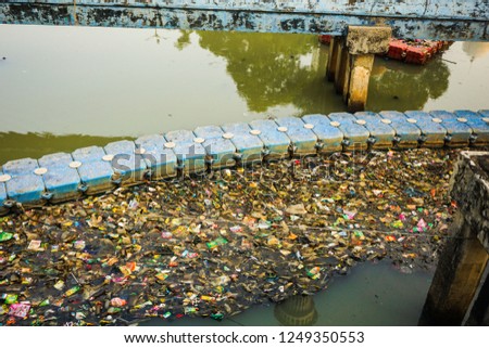 trash and garbage on the water and block water flow in indonesia Royalty-Free Stock Photo #1249350553