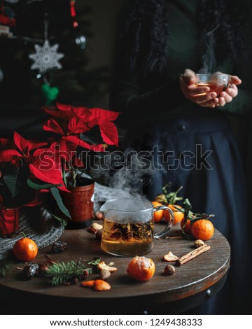 Chritmas chinese tea with steam smoke and mandarins on the black rustic background