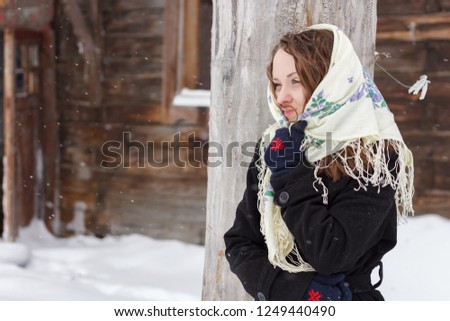 Portrait of a beautiful Slavic woman. In the national headscarves. Outside in a winter snowy day. Russian style girl