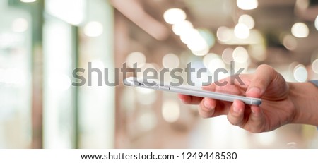 Hand using smart phone over blur bokeh light background, business and technology, internet of things concept