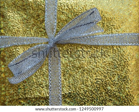 closeup white ribbon on gold gift box
