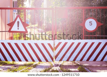 The closed gate with restrictive signs. 
Iron gate on railway tracks. The concept way is closed