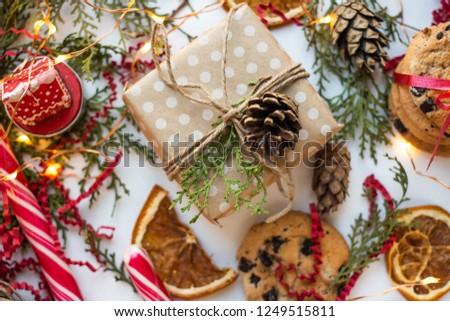 gift box on table with cookies, candies and lights. dry orange slices, candles.