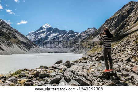 Man visits Mount cook, New Zealand. Young tourist photographing natural landscape.  Popular tourist destination of New Zealand. South island is popular among tourist, travelers and locals.